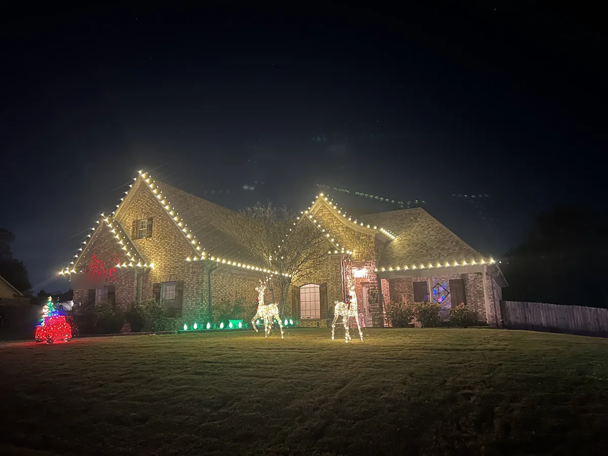 Brick home with warm white C9 lights on every gable at night